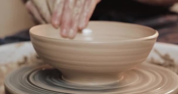Potter en la rueda alfarera hace producto de cerámica utilizando sus manos y herramientas de cerámica. De cerca. Hecho a mano, artesanal. Arcilla blanca — Vídeo de stock