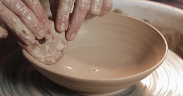 Potter dans la roue des potiers fabrique des produits céramiques à l'aide de ses mains et de ses outils de poterie. Ferme là. Fait main, artisanat. Argile blanche — Video