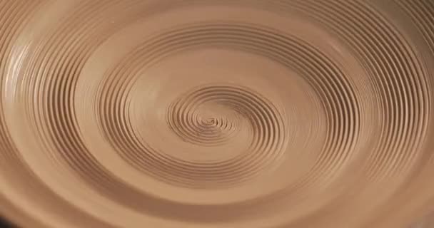 An empty plate with relief rotates on the pottery wheel, close up. Winding clay structure. Handmade, craft. White clay. Top view. — Stock Video