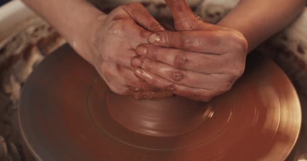 Garncarz sprawia, że garncarstwo z gliny bliska. Tworzenie wyrobów ceramicznych z czerwonej gliny. Kółko do garnków skręconych. Man ręce podejmowania gliniany dzbanek. Ręcznie robione, rzemieślnicze. — Wideo stockowe