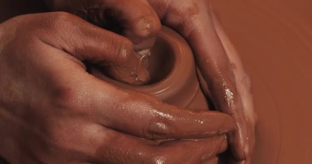 Potter makes pottery from clay close up. Making ceramic products from red clay. Twisted potters wheel. Man hands making clay jug. Handmade, craft. — Stock Video