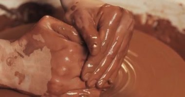 Çömlekçi kilden çömlekçiliği yakın alakadar yapar. Kırmızı kilden seramik ürünler yapmak. Bükülmüş çömlekçi tekerleği. Kil sürahi yapan adam elleri. El yapımı, zanaat.