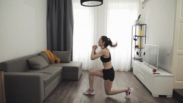 Genç bir kadın evde sağlıklı bir yaşam için spor yapıyor. Ağır çekim. Sağlıklı ve spor yaşam tarzı. — Stok video