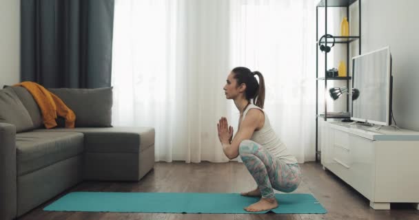 Mujer joven haciendo yoga en casa. Estilo de vida saludable y deportivo . — Vídeo de stock