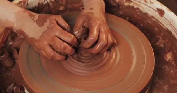 Hände arbeiten an der Töpferscheibe und formen ein Relief auf einer Tonplatte. Töpfer bei der Arbeit, aus nächster Nähe. Handarbeit, Handwerk. roter Ton. — Stockvideo