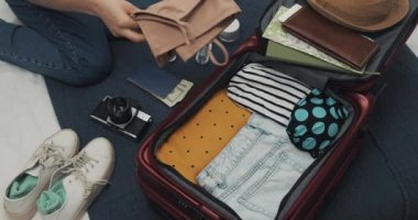 Kadınlar evde yatakta bir yolculuk için bavul ambalaj eller. Seyahat hazırlıkları.