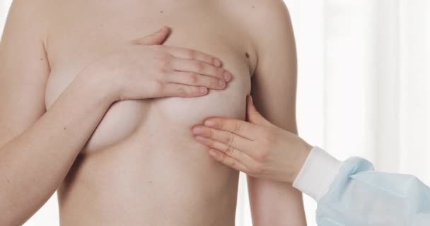 医師は病院で女性の乳房をチェックします。乳がん予防クローズアップ. — ストック動画