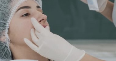 Dudak Büyütme, yakın çekim. Doktor kozmetolojist bir güzellik salonunda güzel bir kadının dudak büyütme prosedürü için hazırlanıyor. Kozmetik güzellik enjeksiyon konsepti.