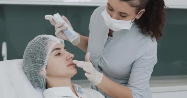 Aumento de labios, de cerca. El doctor el cosmetólogo que se prepara para el procedimiento del aumento labial de la mujer hermosa en el salón de belleza. Concepto cosmético de inyección de belleza . — Vídeo de stock