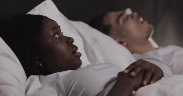 Multietniskt par som ligger i sängen tillsammans. Kvinnan lider av sin partner snarkning i sängen. Par livsstil och människor vårdkoncept. — Stockvideo