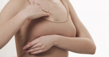 Göğüs kanseri belirtileri için göğüslerini kontrol eden bir kadın. Sağlık ve mamoloji konsepti. Kapat..