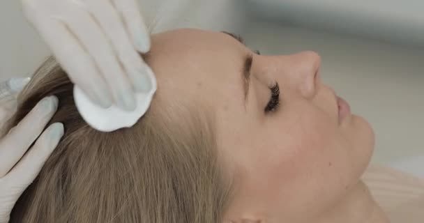 Mujer atractiva joven recibe mesoterapia para el cabello. La chica recibe una inyección en la cabeza. De cerca. . — Vídeos de Stock