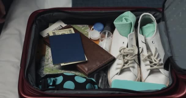 Женские руки распаковывают чемодан для путешествия по кровати дома. Подготовка к поездке . — стоковое видео