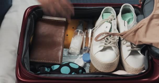 Las mujeres manos haciendo las maletas para un viaje en la cama en casa. Preparativos de viaje . — Vídeos de Stock