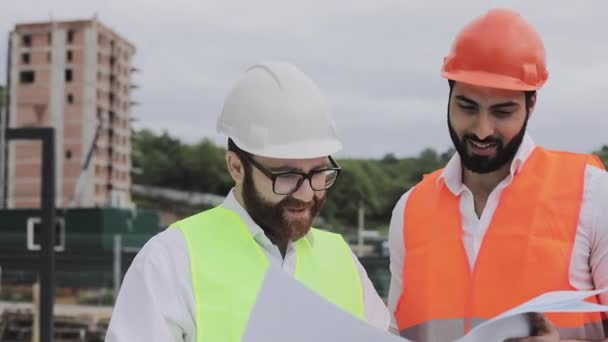 Bau einer Wohnanlage oder eines Geschäftszentrums. Team von Ingenieuren Männer analysieren Pläne Bauarbeiter Job-Aktivität. Experten sind mit dem Bauplan zufrieden. — Stockvideo