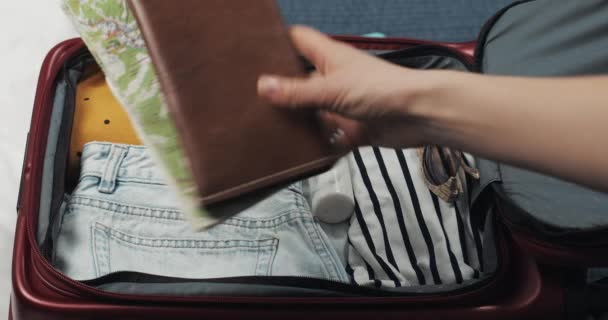 Las mujeres manos haciendo las maletas para un viaje en la cama en casa. Preparativos de viaje . — Vídeo de stock