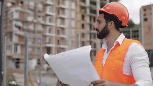 Architect man lopen op de bouwplaats en het analyseren van schema projectplan. Buiten, Slow Motion. — Stockvideo