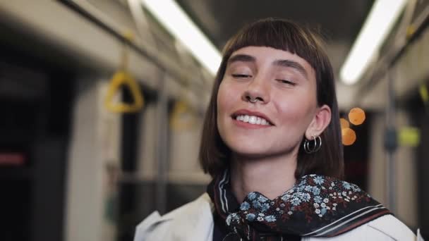 Bella donna che guarda la macchina fotografica nel tram e sorride, fermo macchina girato. Primo piano . — Video Stock