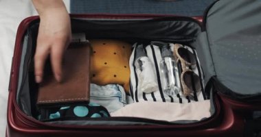 Kadınlar evde yatakta bir yolculuk için bavul ambalaj eller. Seyahat hazırlıkları.