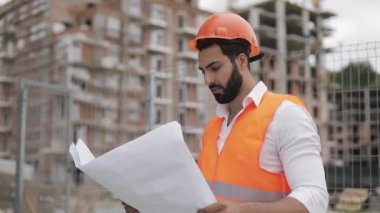 Mimar adam şantiyede yürüyüş ve analiz şeması proje planı. Dış, yavaş çekim.