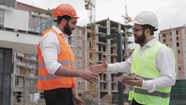 Gerente de construção e trabalhadores apertando as mãos no canteiro de obras. Profissões, construção, trabalhadores, conceito de arquiteto . — Vídeo de Stock