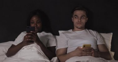 Çok ırklı çift geceleri yatakta yatan akıllı telefonlar kullanıyor. Adam kadınının telefonuna bakıyor, kadın ondan uzaklaşıyor. Casusluk, karmaşık ilişkiler. Güven yok.
