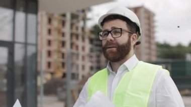 Mimar adam şantiyede yürüyüş ve analiz şeması proje planı. Dış, yavaş çekim.