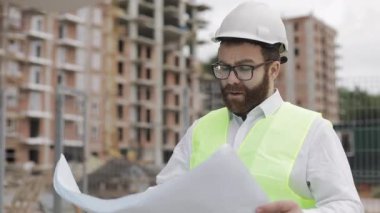 Mimar adam şantiyede yürüyüş ve analiz şeması proje planı. Dış, yavaş çekim.