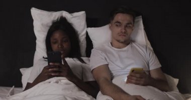 Çok ırklı çift geceleri yatakta yatan akıllı telefonlar kullanıyor. Adam kadınının telefonuna bakıyor, kadın ondan uzaklaşıyor. Casusluk, karmaşık ilişkiler. Güven yok.