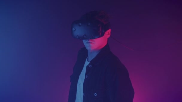 Porträt eines attraktiven jungen Mannes mit Vr-Brille, der in die Kamera mit rosa Hintergrund blickt, Nahaufnahme. Virtual Reality Konzept. — Stockvideo