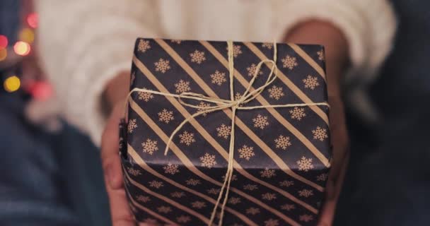 Nahaufnahme einer schönen Weihnachtsgeschenkschachtel in Frauenhänden. Konzept für Weihnachts- und Neujahrsfeiern. — Stockvideo