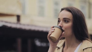 Pretty Genç Happy Girl İçme Coffe Smile Yürüyüş Rahat Eski Şehir Arka Plan Close Up Yavaş Hareket Sağ Yan Görünümü Portresi.