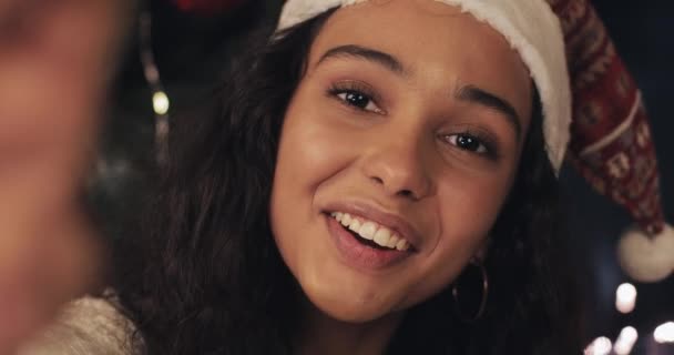 Close-up Mobiele telefoon Camera View of Beautiful Smiling Girl in Santas Hoed Het hebben van videogesprek, Op zoek naar opgewonden, zwaaien, Praten Lachen. Communicatie en Kerstvakantie Concept. — Stockvideo