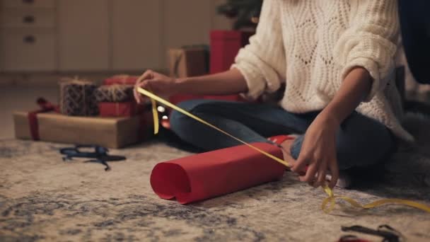 Close Up of Young Woman Hands Preparing Christmas Presents, Bandaging Yellow Ribbon Sitting on the Floor near Presents at Home Background. Concept of Holidays and New Year. — Stock Footage Close Up of Young Woman Hands Preparing Christmas Presents, Bandaging Yellow Ribbon Sitting on the Floor near Presents at Home Background. Concept of Holidays and New Year. Stock Video