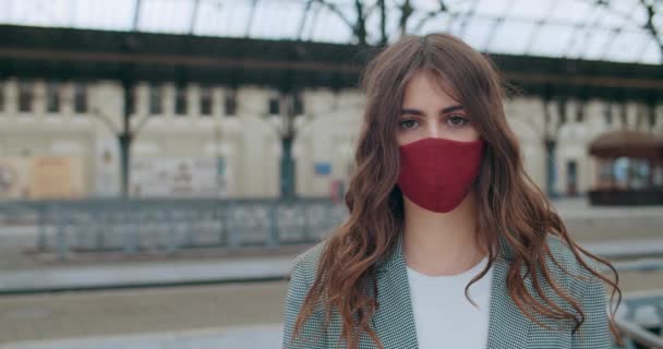 Close up view of adult girl in handmade protective mask looking to camera. Portrait of serious young brunette female standing alone. Outdoors. Concept of virus pandemic. — Stock Video