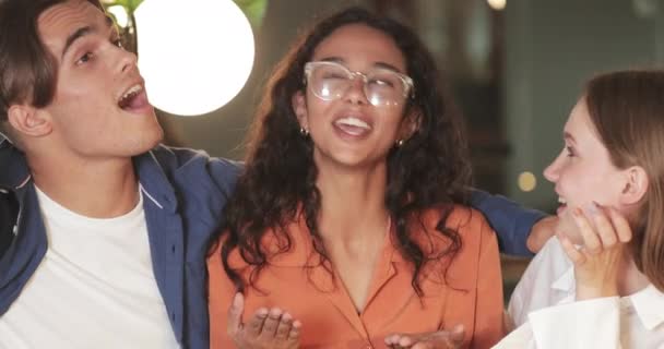 Crop view de jeunes amis joyeux riant et parlant tout en ayant du bon temps au café. Groupe de personnes multiethniques communiquant. Concept d'amitié et d'émotions positives.