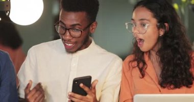 Cihazlarını kullanırken fikir arayan gençleri kapatın. Genç Afro-Amerikan adam, üniversitelere akıllı telefon içeriği gösteriyor ve seviniyor. Başarı ve takım çalışması kavramı.
