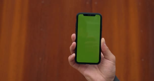 Närbild av manliga hand höja upp copyspace hånade upp skärmen smartphone. Begreppet kromnyckel, grön skärm och teknik. suddig rost bakgrund. — Stockvideo
