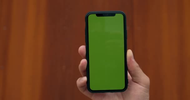Närbild av manlig hand som håller copyspace hånade upp skärmen mobiltelefon. Begreppet kromnyckel, grön skärm och teknik. suddig rost bakgrund. — Stockvideo