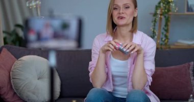 Akıllı telefonun önünde oturan ve güzellik vlog 'u için video kaydeden bir kadın konuşuyor ve kozmetik sünger gösteriyor. Sosyal ağların makyajı hakkında yeni bir bölüm hazırlayan kadın vloger.