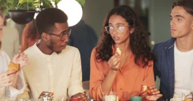 Neşeli kız, arkadaşlarıyla kafede vakit geçirirken onlara komik bir hikaye anlatıyor. Yemek yerken iletişim kuran bir grup genç insan. Dışarıda yemek yeme kavramı.