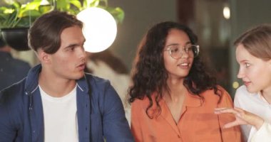 Mola sırasında birlikte otururken neşeli gençlerin sohbet edişine yakından bakın. Milenyum arkadaşları birlikte vakit geçirirken sohbet ediyorlar. İletişim kavramı.