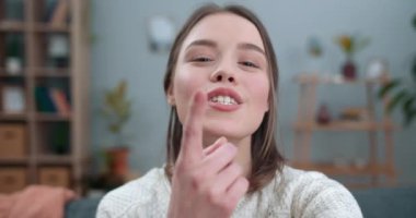 Neşeli kadın görüntüsü yakın çekimde. Video görüşmesi yapıyor ve akıllı telefonun ön kamerasını kullanıyor. Kadın gülüyor ve işaret diliyle konuşuyor. Seni özlüyorum. Sağır engeli kavramı..
