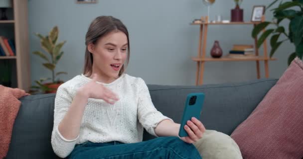 Attraktiv döv kvinna som har videosamtal och visar med teckenspråk Hej, Kul att se dig. Kvinnlig glad person ler och använder smartphone för kommunikation. Begreppet hörselförlust. — Stockvideo