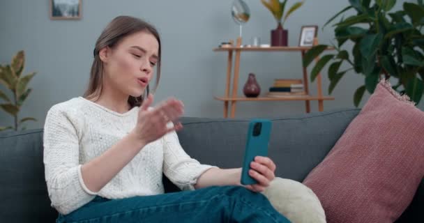 Crop view of woman with hearing loss communicating on smartphone and usign sign language.Smiling female person having vídeo call and showing with finger spelling phrase Ir para o café. — Vídeo de Stock