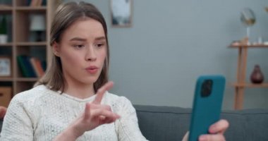 Sağır bir kadının video konuşması ve işaret dili cümlesiyle gösterilmesi korkunç bir haber. İletişim için akıllı telefonu kullanırken üzgün görünen bir kadın. İşitme kaybı.