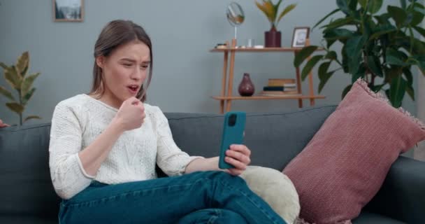 Alegre sorda persona femenina que tiene videollamada y muestra con la frase de lenguaje de señas Ir a tomar un café. Hermosa mujer sonriendo y utilizando el teléfono móvil para la comunicación. Concepto de pérdida auditiva. — Vídeos de Stock