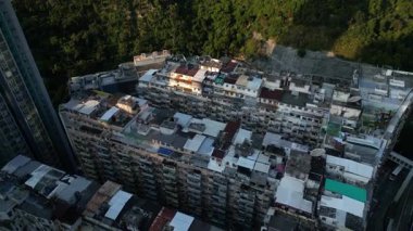 Quarry Bay, Hong Kong 'daki ünlü Canavar Binası' nın insansız hava aracı görüntüsü yeşilliklerle çevrili yoğun konutları gösteriyor.