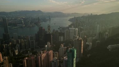 Günbatımında Victoria Limanı ve modern gökdelenlerle birlikte Hong Kong 'un hava manzarası yoğun gökyüzü ve ikonik şehir manzarasını gözler önüne seriyor..