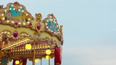 Parlayan lambalar ve akşam gökyüzünün altında dönen şehir resimleriyle eski moda bir atlıkarınca. Viyana, Avusturya 'daki Noel panayırında klasik atlı karınca misafirleri eğlendiriyor. Tatil ortamı